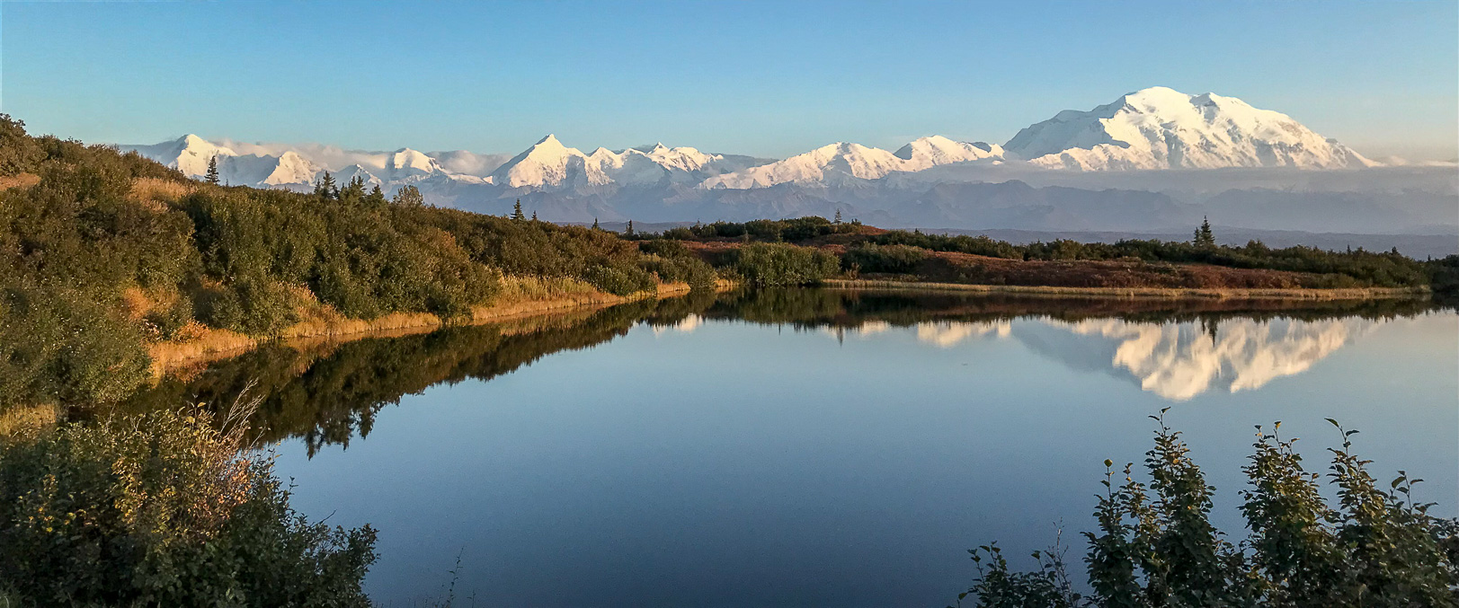 Bergskedjan Alaska Range sträcker sig från Alaska till sydvästra Kanada. Mount Denali ("Den Höge") är Nordamerikas högsta bergstopp. Här speglas den i Reflection pond.